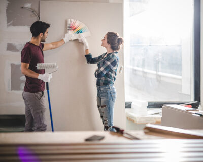 Young couple choosing the right color for their wall while renovating apartment