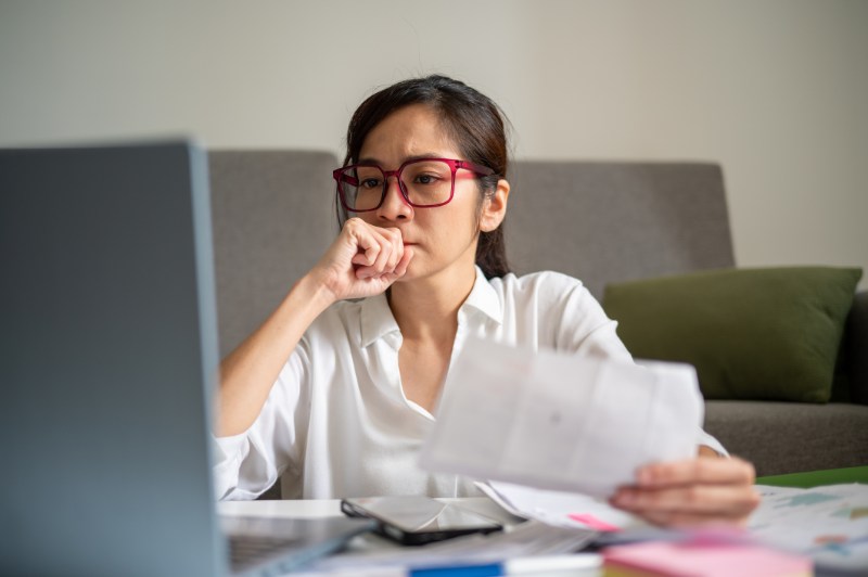 Anxious Young Woman Going Through Household Bills Online