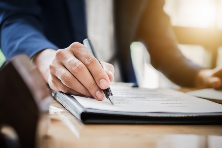 Estate agent gives pen and documents agreement